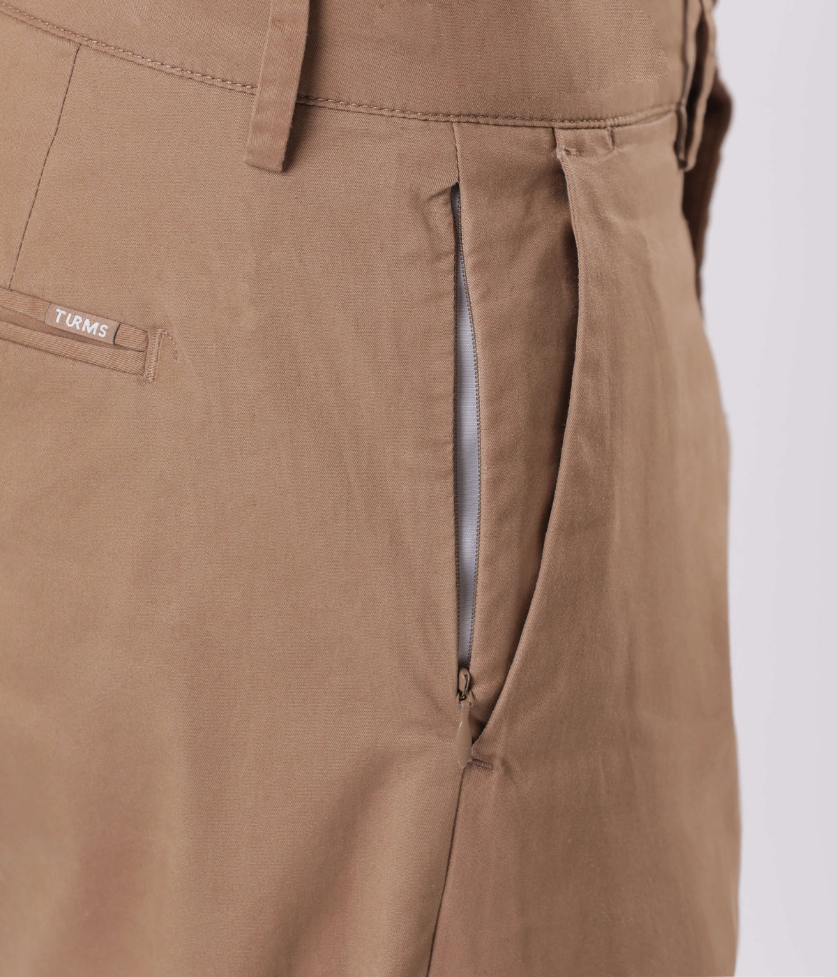 Close-up of Turms smart flex Chino detailing, showcasing the zipper and fabric of Dessert Mirage.