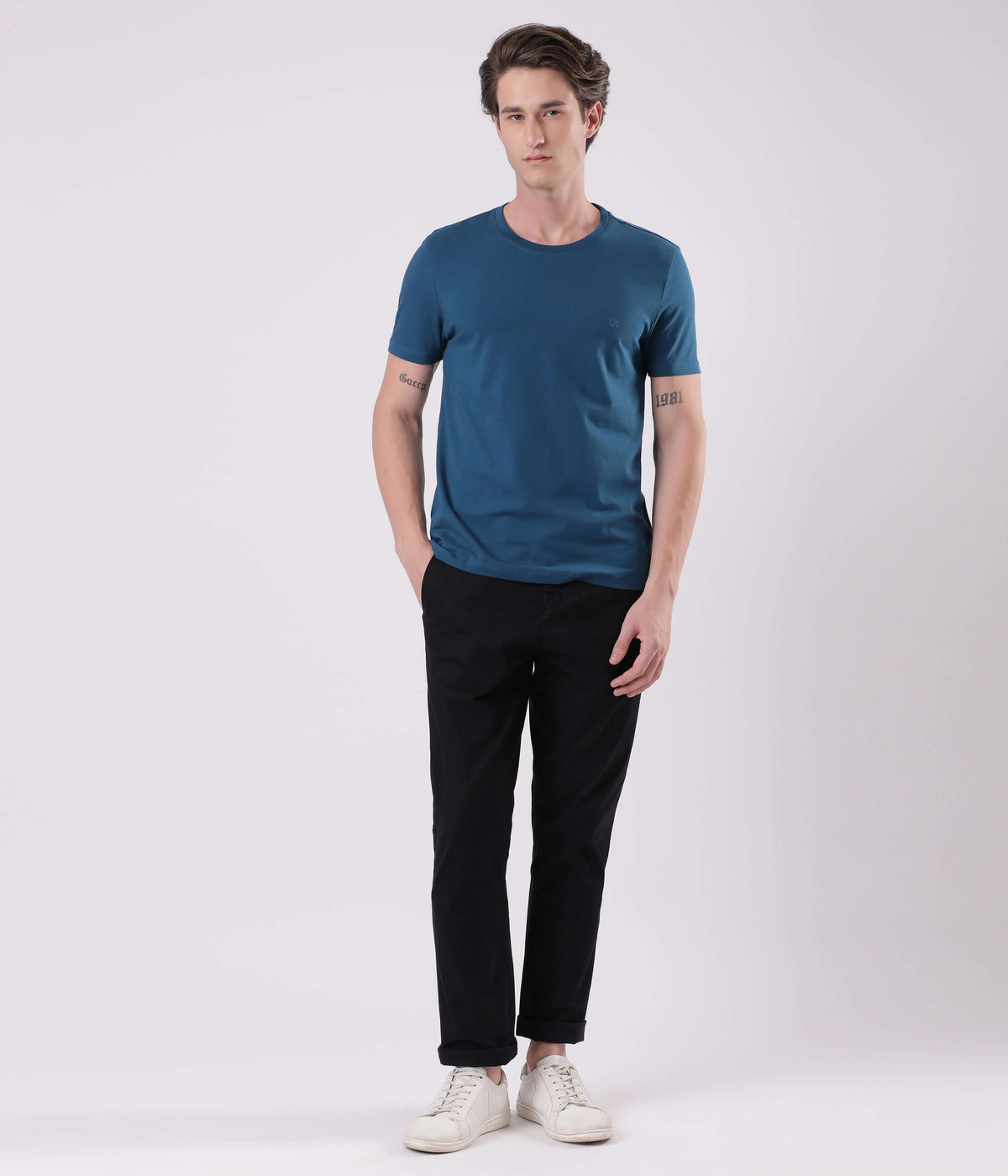 Model wearing Turms Black Sea smart flex Chino with a blue t-shirt and white sneakers.