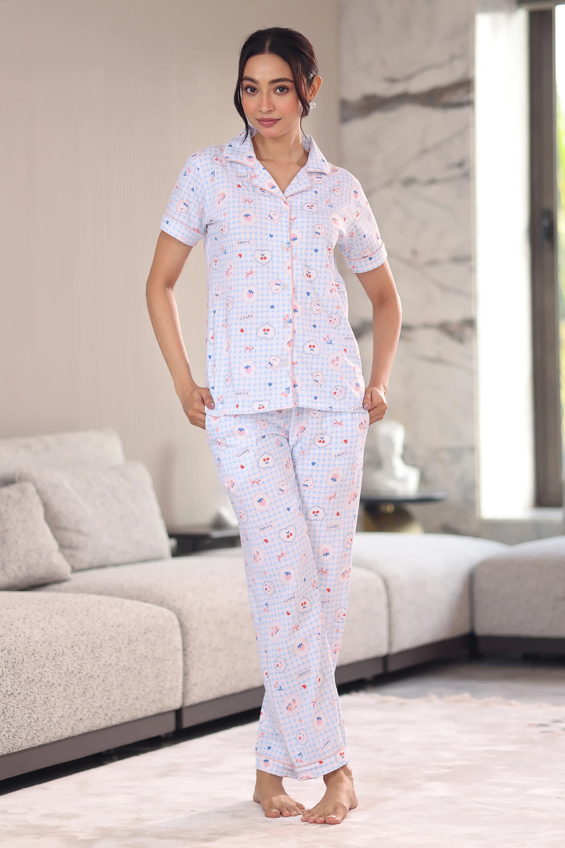 Woman wearing a patterned pajama set in a modern living room.