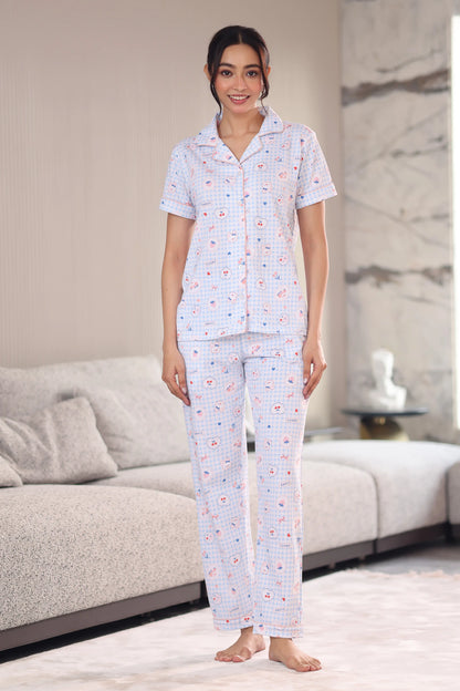 Woman wearing a patterned pajama set in a living room.