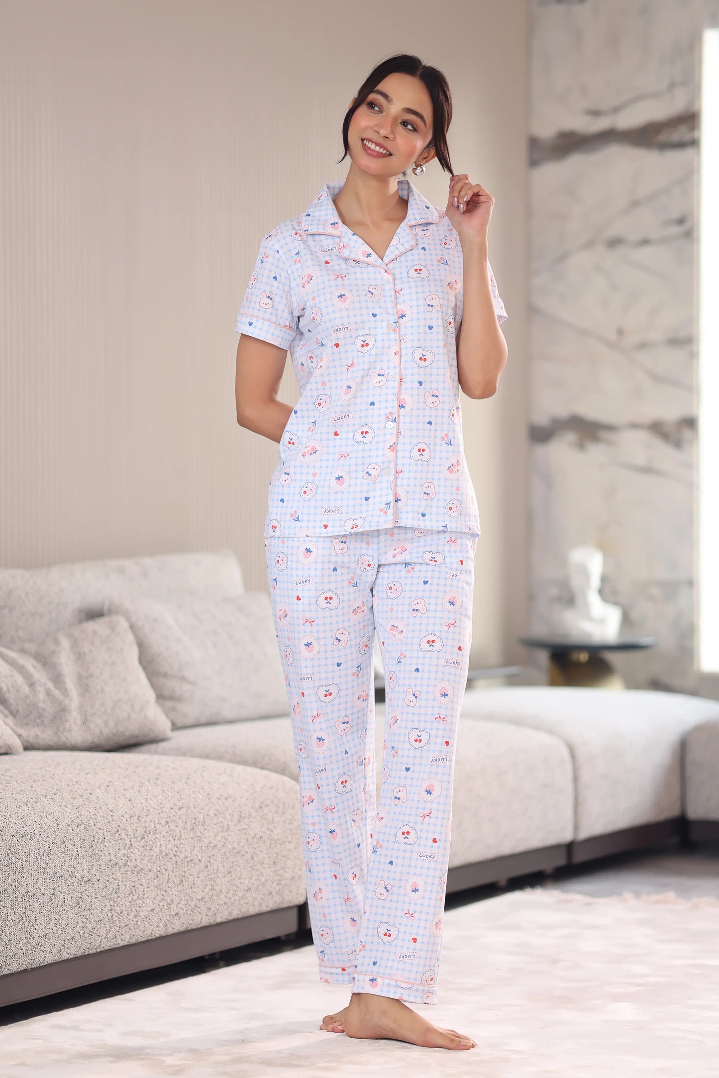 Woman wearing a patterned pajama set in a living room.