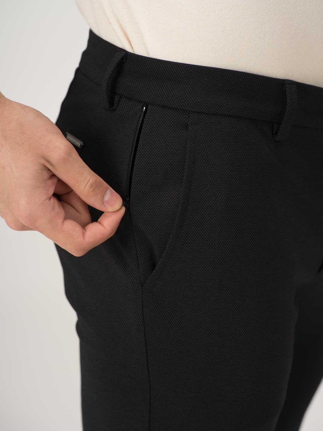 Close-up view of black stretchable trousers by pant project, focusing on the zipper detail