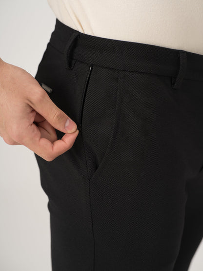 Close-up view of black stretchable trousers by pant project, focusing on the zipper detail
