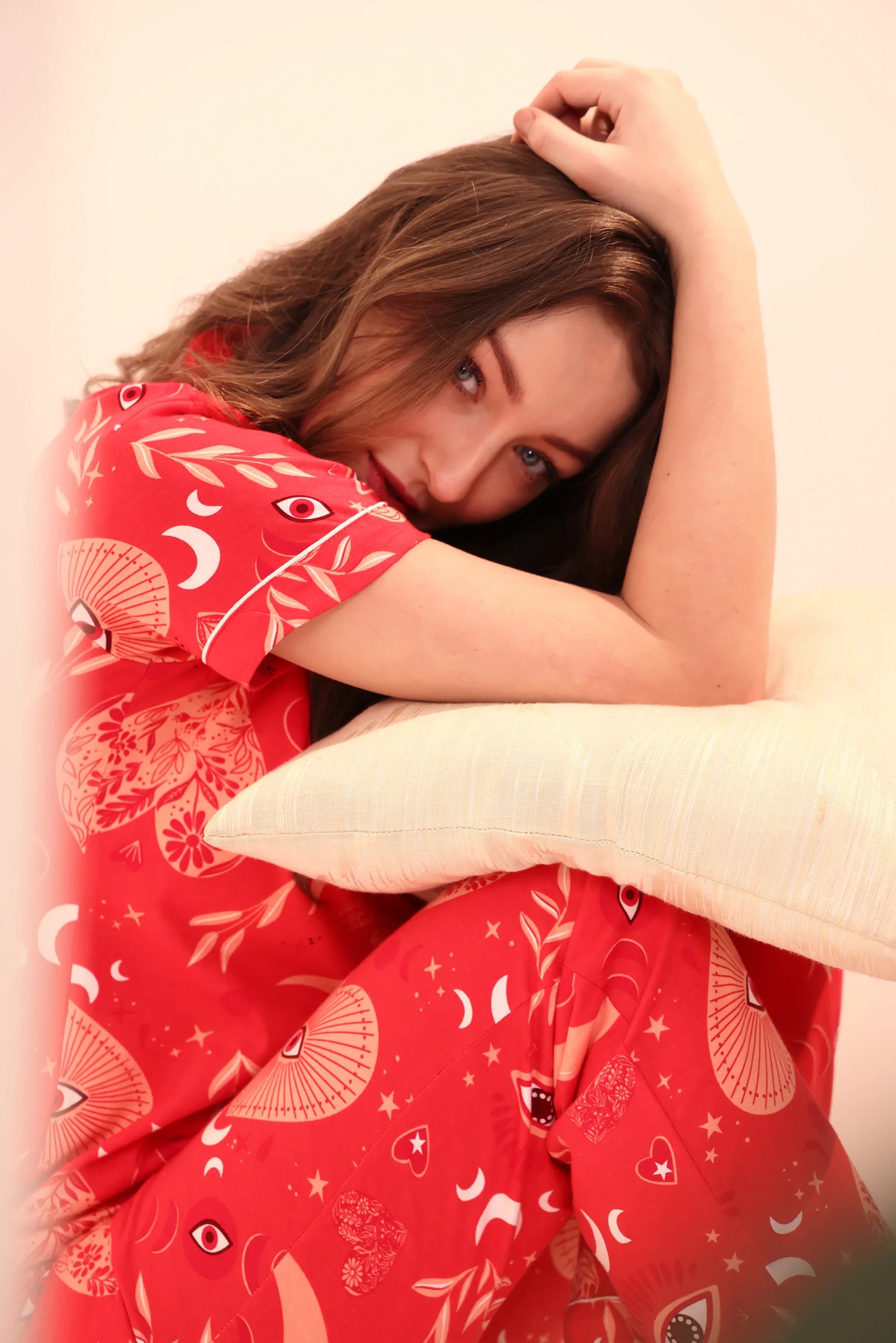 Young girl resting head on arms in red Lovespell Print breathable 100% cotton Pyjama Set by NapStory.