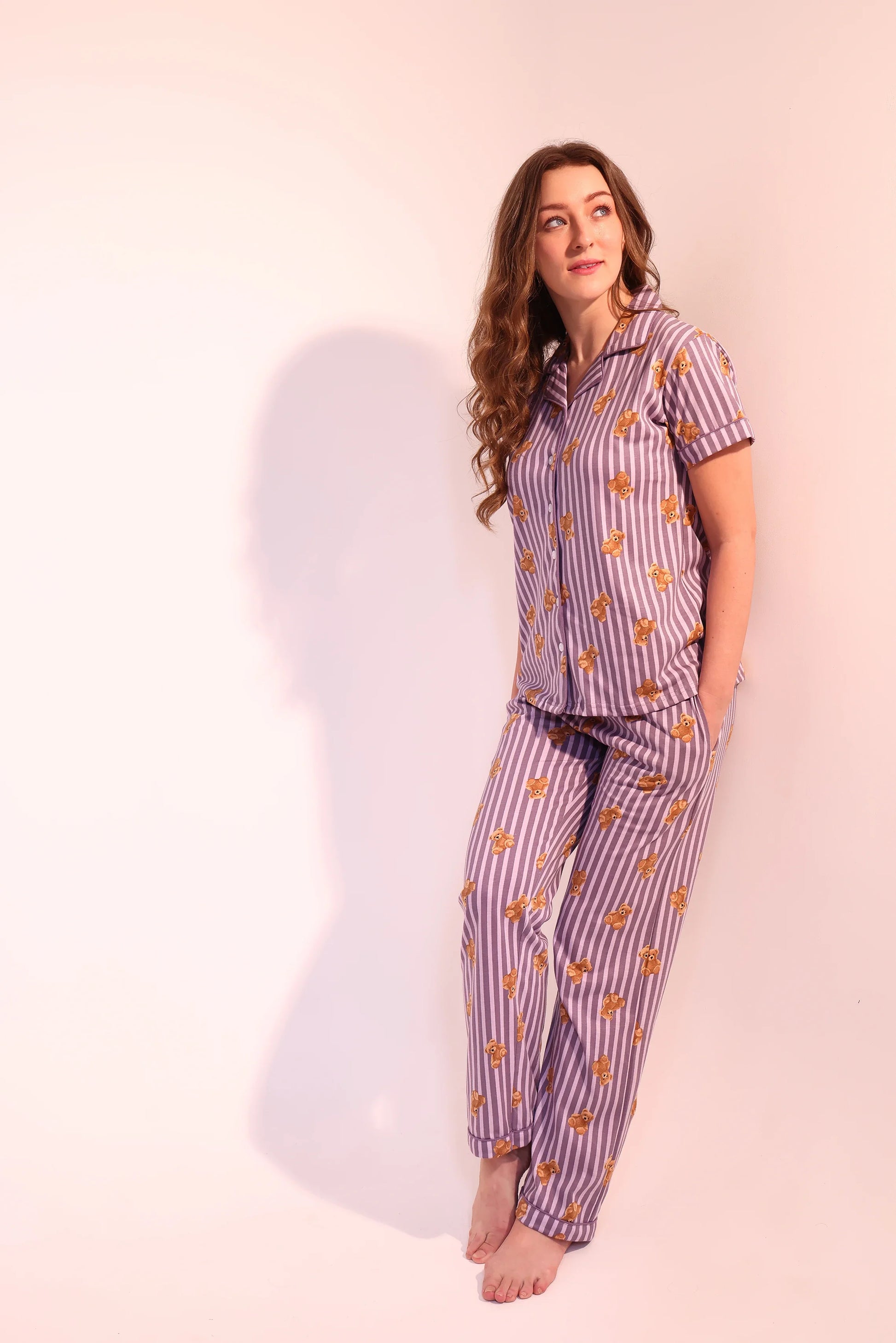 Woman standing barefoot and smiling in breathable Teddyboo print Pyjama Set nightwear by NapStory.